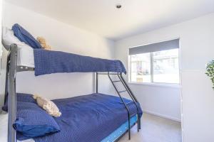 a bedroom with a bunk bed with blue sheets at Nannys Beach House in Berrara
