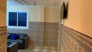 a living room with a couch and a tv at Kornich in Nador