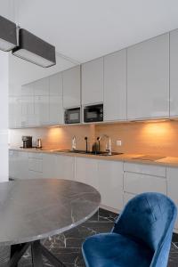 a kitchen with a table and a blue chair at RentPlanet - Apartamenty OVO in Wrocław