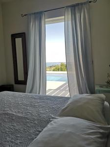 - une chambre avec un lit et une fenêtre avec vue dans l'établissement Fiora Villas, à Trapezaki