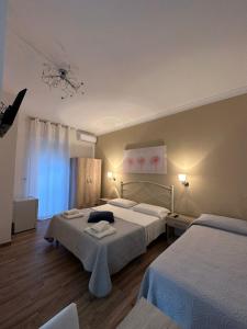 una camera d'albergo con due letti e un lampadario a braccio di Giardino dei Baroni house a Marina di Mancaversa