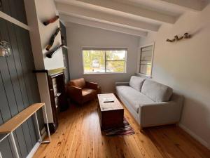 a living room with a couch and a table at Sunflower House, a cozy cabin at Lake Wentworth in Wentworth Falls