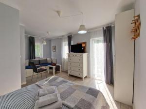 a bedroom with a bed and a living room at Szafranówka in Władysławowo