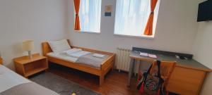 Habitación pequeña con cama y escritorio. en Magellan Apartments en Belgrado