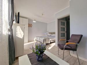 a bedroom with a bed and a chair and a vase of flowers at Szafranówka in Władysławowo