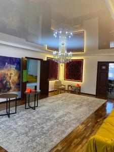 a living room with a chandelier and a rug at Ayla Hostel in Osh