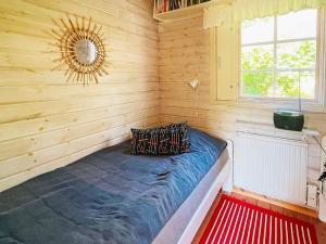 um quarto com uma cama azul numa parede de madeira em Holiday home ELLÖS VII em Ellös