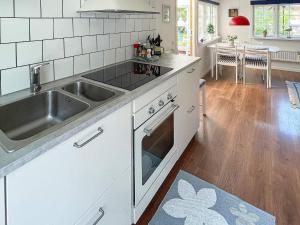 eine Küche mit einer Spüle und einem Herd Top-Backofen in der Unterkunft Holiday home SÖLVESBORG X in Sölvesborg