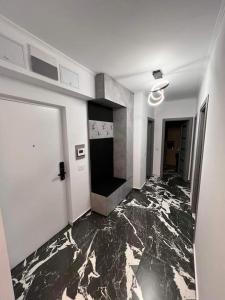 een kamer met een marmeren vloer en een witte deur bij Luxury Apartments by Patrik in Oradea