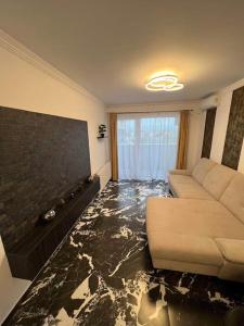 een woonkamer met een bank en een tv bij Luxury Apartments by Patrik in Oradea