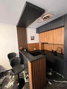 cocina con encimera negra y 2 sillas en Luxury Apartments by Patrik, en Oradea