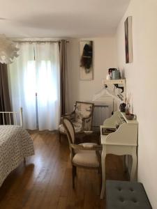 1 dormitorio con mesa, silla y escritorio en Les Allumettes d'Ecorsaint, en Écorsain