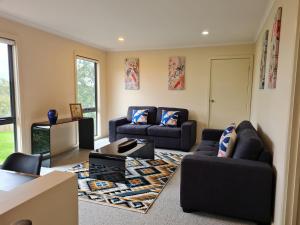 a living room with two couches and a rug at Bungunyah Apartments in Croydon