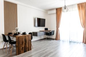 una sala de estar blanca con mesa y sillas en Ego Apartments, en Băile Felix