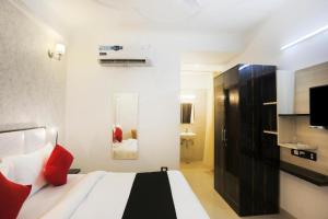 a bedroom with a large bed with red pillows at M K HOTEL AND RESTAURANT in Greater Noida