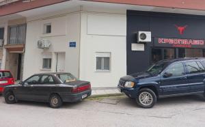 two cars parked in front of a building at Ioa Loft in Ioannina