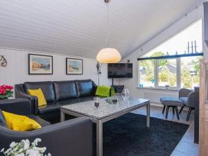 ein Wohnzimmer mit einem Sofa und einem Tisch in der Unterkunft 6 person holiday home in Ulfborg in Vang