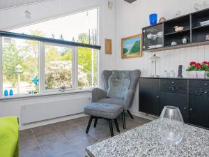 ein Wohnzimmer mit einem Stuhl und einem Fenster in der Unterkunft 6 person holiday home in Ulfborg in Vang