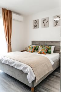 Habitación blanca con cama grande con almohadas en Ego Apartments, en Băile Felix