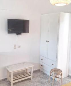 a living room with a table and a tv on a wall at Voula Accommodation in Agios Georgios