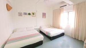 a bedroom with two beds and a window at "Cloth Art Homestay" walk to Pahlawan & Jonker by Shine Stay in Melaka