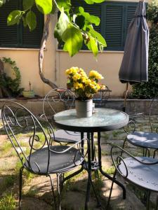ein Tisch und Stühle mit einer Blumenvase drauf in der Unterkunft B&B Uva Fragola in Perugia