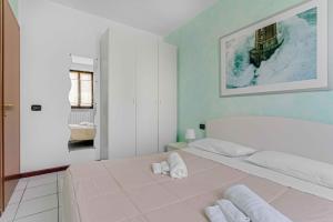 a bedroom with a large white bed with towels on it at -Free Parking & Pool- Casa a pochi passi dal Lago in Padenghe sul Garda