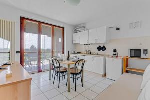 a kitchen with a table and some chairs in it at -Free Parking & Pool- Casa a pochi passi dal Lago in Padenghe sul Garda