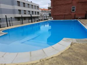 a large blue swimming pool in front of a building at Casa Antonia Portosín in Portosin