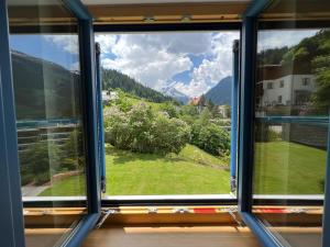 a window with a view of a green field at Charming chalet with sauna + views! in Bad Gastein