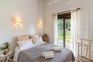 una camera da letto con un letto e due asciugamani di #Calypso by halu! Sani Villas a Sani Beach