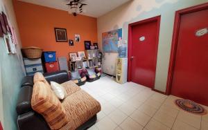 a living room with a couch and a red door at Putrajaya Transit Romestay in Putrajaya