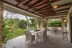 un patio esterno con tavolo e sedie di #Calypso by halu! Sani Villas a Sani Beach