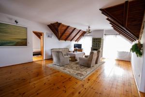 a living room with a couch and chairs and a table at Holiday home Jarzębinowa 9 in Rowy