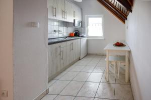 a kitchen with white cabinets and a table at Holiday home Jarzębinowa 9 in Rowy