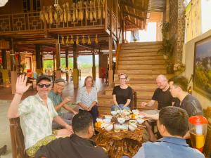 eine Gruppe von Menschen, die um einen Tisch sitzen in der Unterkunft Bac Son Homestay in Bắc Sơn