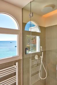 a bathroom with a shower and a window at Universal Hotel Aquamarin in Sant Elm