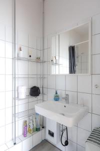 een witte badkamer met een wastafel en een spiegel bij LULEX I - Luxus Apartment Krefeld Alexanderplatz in Krefeld