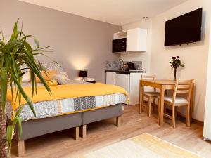 a bedroom with a bed and a table and a kitchen at Maison De La Tour in Saint-Émilion