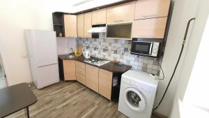 een keuken met een koelkast en een wasmachine bij FlatRent Apartment in Bisjkek