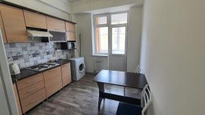 een kleine keuken met een tafel en een fornuis bij FlatRent Apartment in Bisjkek