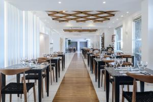 una fila di tavoli e sedie in un ristorante di Dimitra Beach Hotel & Suites ad Ágios Fokás