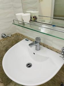lavabo blanco en el baño con espejo en GM Homestay en Hai Phong