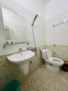 y baño con lavabo, aseo y espejo. en GM Homestay, en Hai Phong