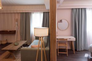 1 dormitorio con cama, mesa y espejo en Niki Athens Suites - Cosy Suite in the historical center of Athens, en Atenas