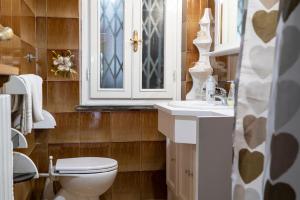 baño con aseo y lavabo y ventana en CASA TERESA, en Loppeglia