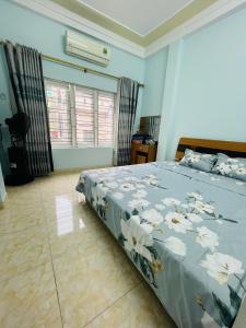 ein Schlafzimmer mit einem Bett mit Blumen darauf in der Unterkunft GM Homestay in Haiphong