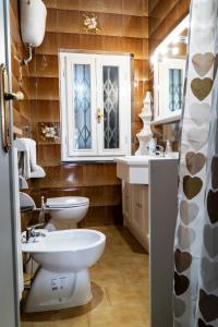 y baño con 2 aseos, lavamanos y espejo. en CASA TERESA, en Loppeglia