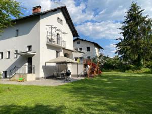 ein großes weißes Haus mit Rasen davor in der Unterkunft VILA ADA - Big Garden - 4 New Quiet Apartments - Free Parking in Ljubljana