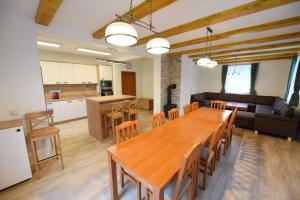 comedor y cocina con mesa de madera y sillas en Chata Zahálka Ramzová en Ostružná